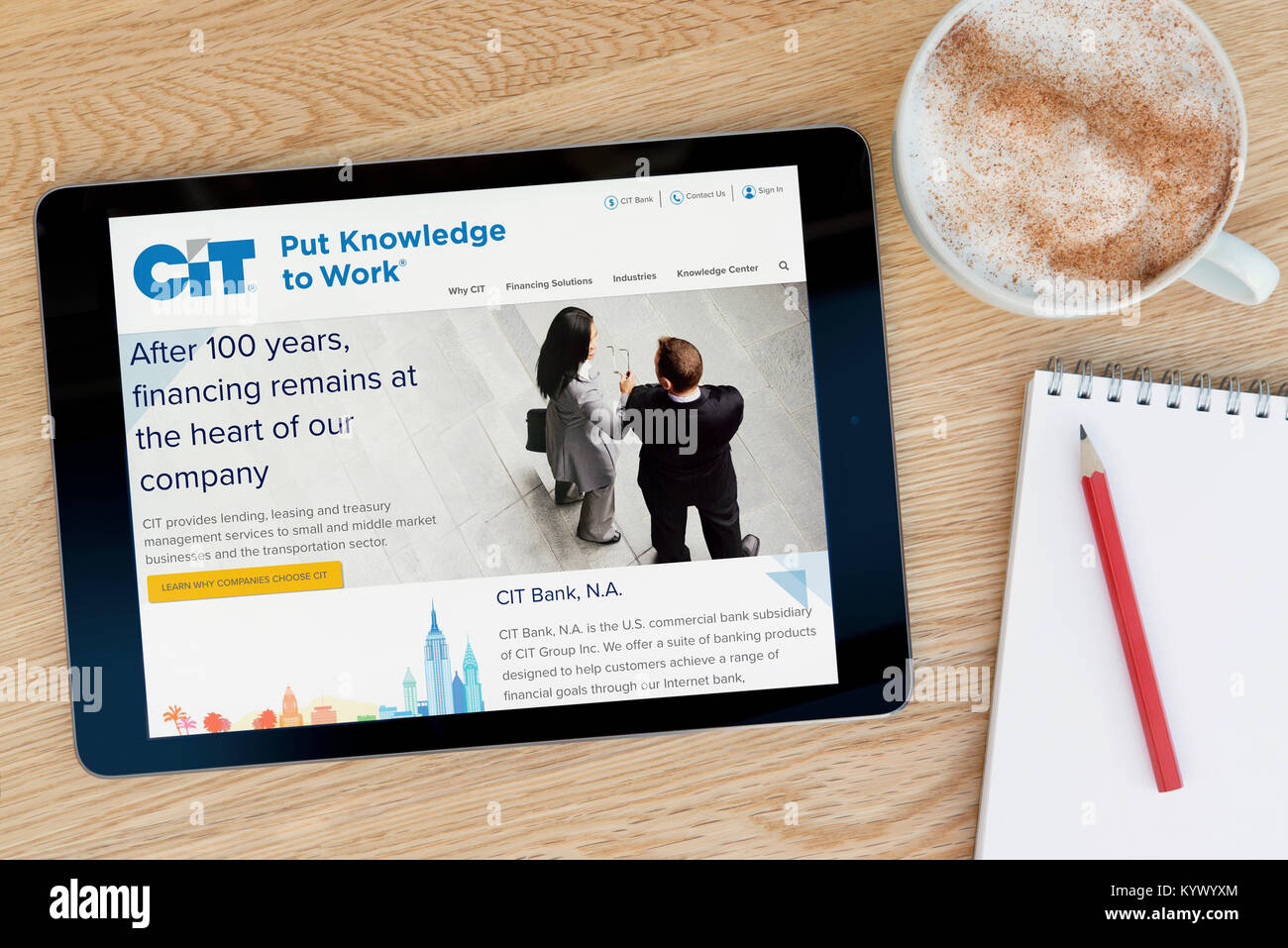 Die CIT Group Website auf einem iPad Tablet, auf einen hölzernen Tisch neben einem Notizblock, Bleistift und Tasse Kaffee (nur redaktionell) Stockfoto