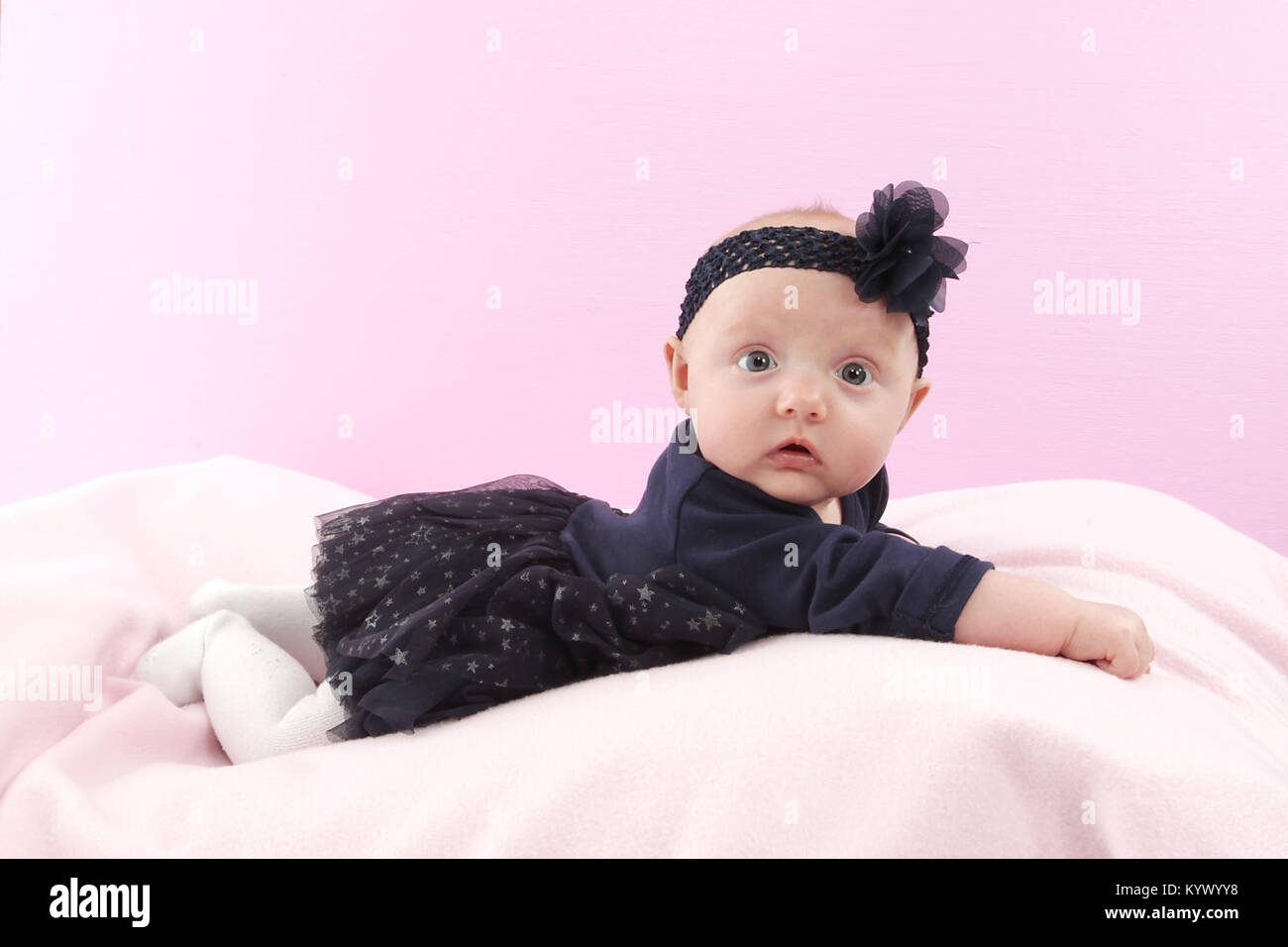 5 Monate altes Baby Mädchen mit in schwarzem Kleid Festlegung auf rosa Decke Stockfoto
