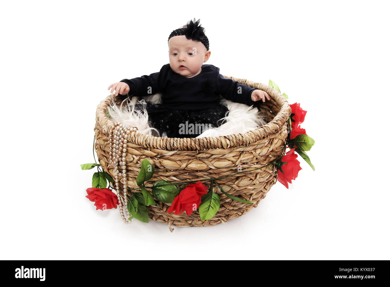 5 Monate altes Baby Mädchen mit in schwarzem Kleid in einem Korb sitzen Stockfoto