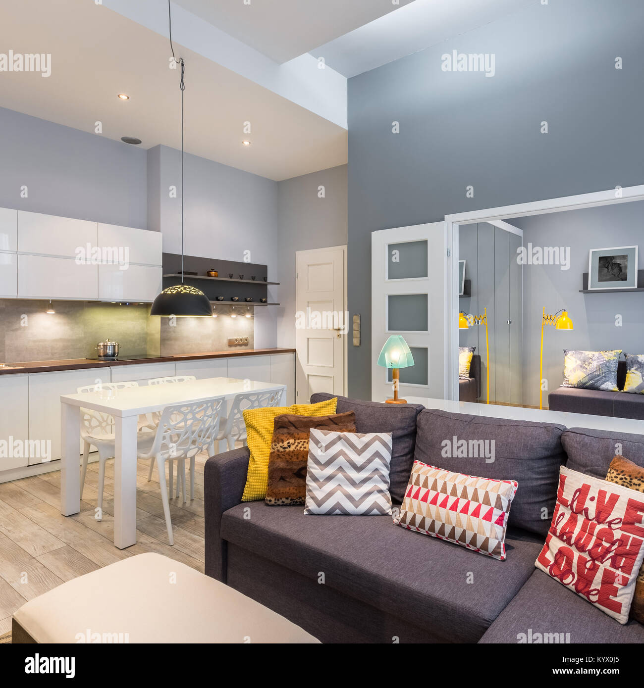 Apartment mit Küchenzeile und Sofa mit bunten, dekorative Kissen Stockfoto