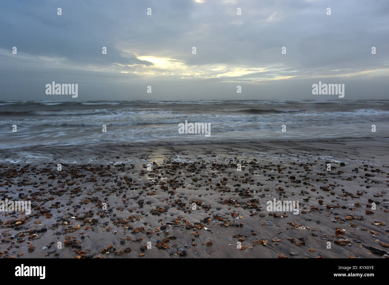 Eine schöne, stimmungsvolle und atmosphärisch Marine auf der Insel Wight. Ein steiniger Strand mit nassem Sand und schlechtes Wetter, Seegang und Wellen. Stockfoto