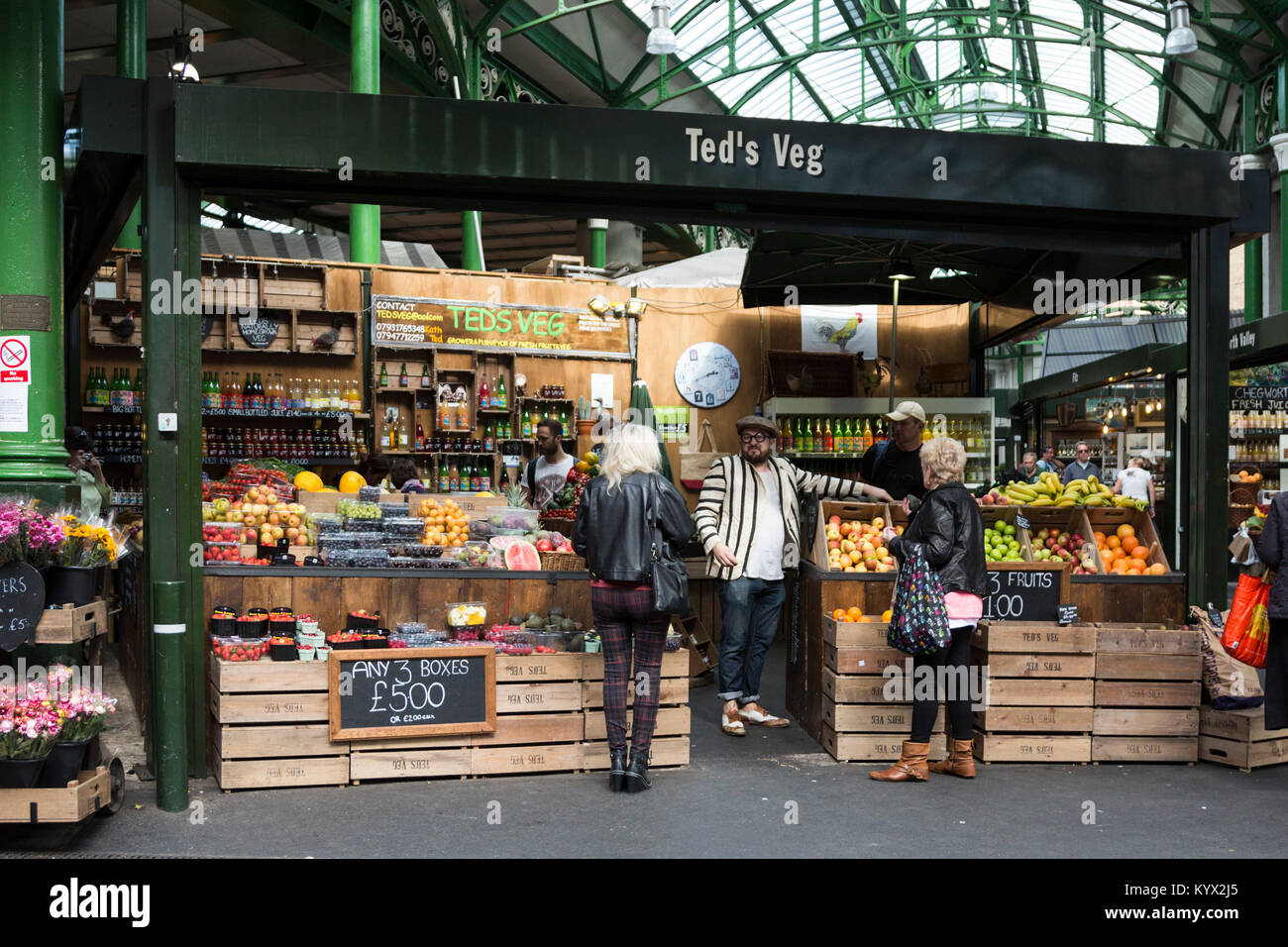 Ted's Gemüse Marktstand, Lebensmittelhändler mit Kunden an Borough Market, London, England, Vereinigtes Königreich Stockfoto