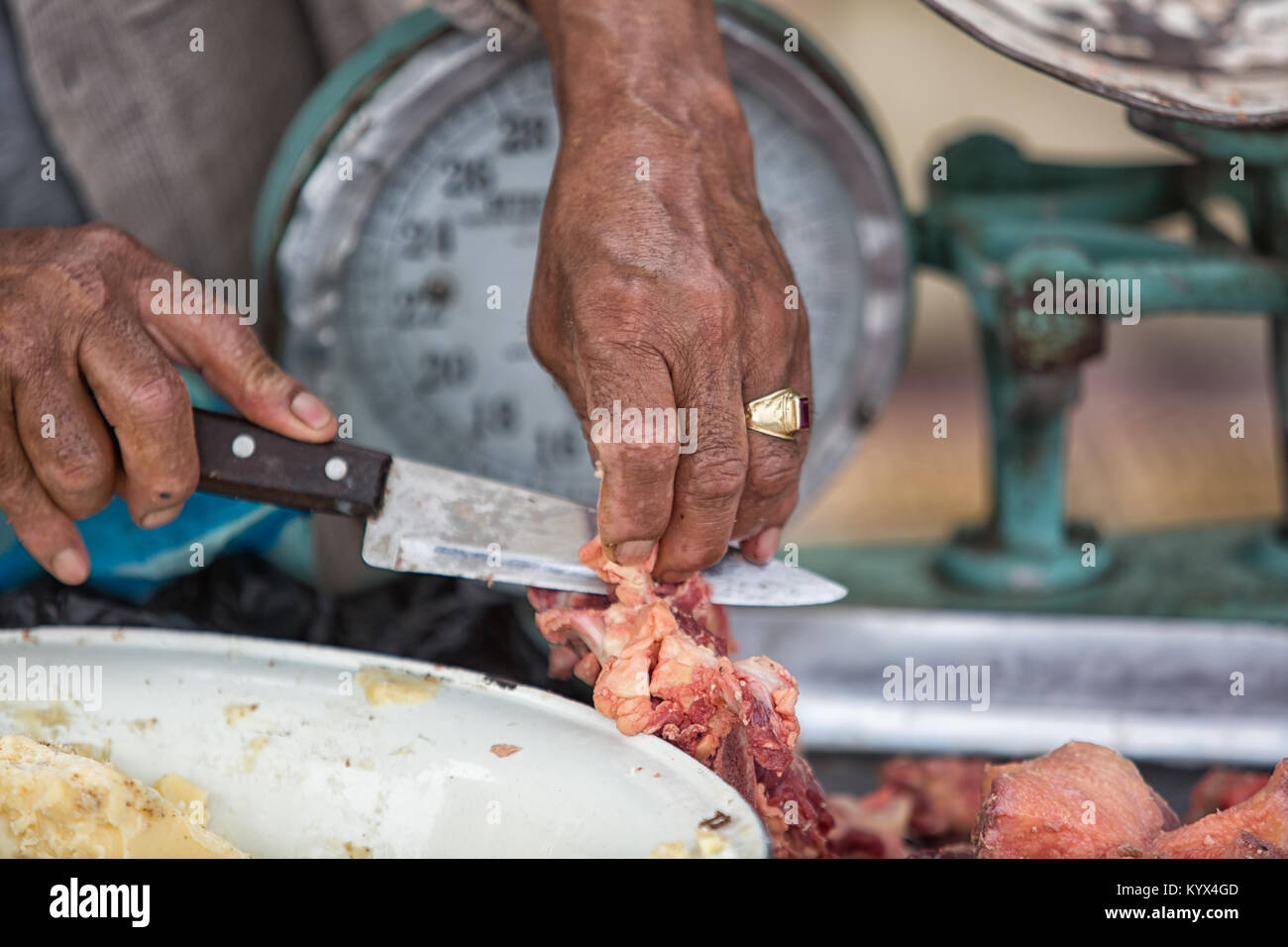 Otavalo, Ecuador - 30. Dezember 2017: Nahaufnahme von Hand schneiden Metzger Fleisch mit Messer in der wöchentliche Bauernmarkt Stockfoto