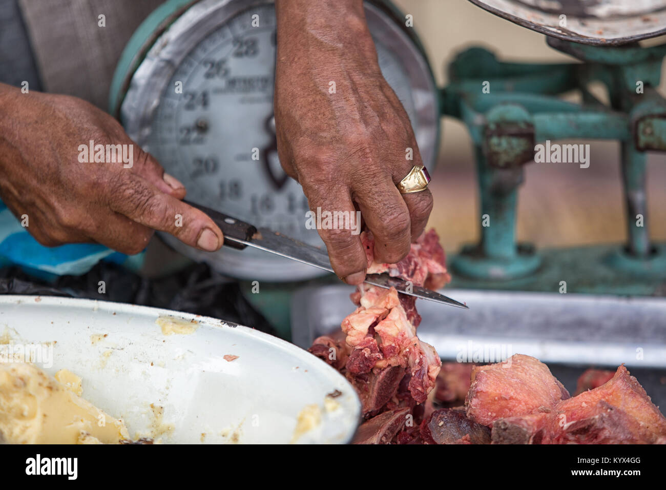 Otavalo, Ecuador - 30. Dezember 2017: Nahaufnahme von Hand schneiden Metzger Fleisch mit Messer in der wöchentliche Bauernmarkt Stockfoto
