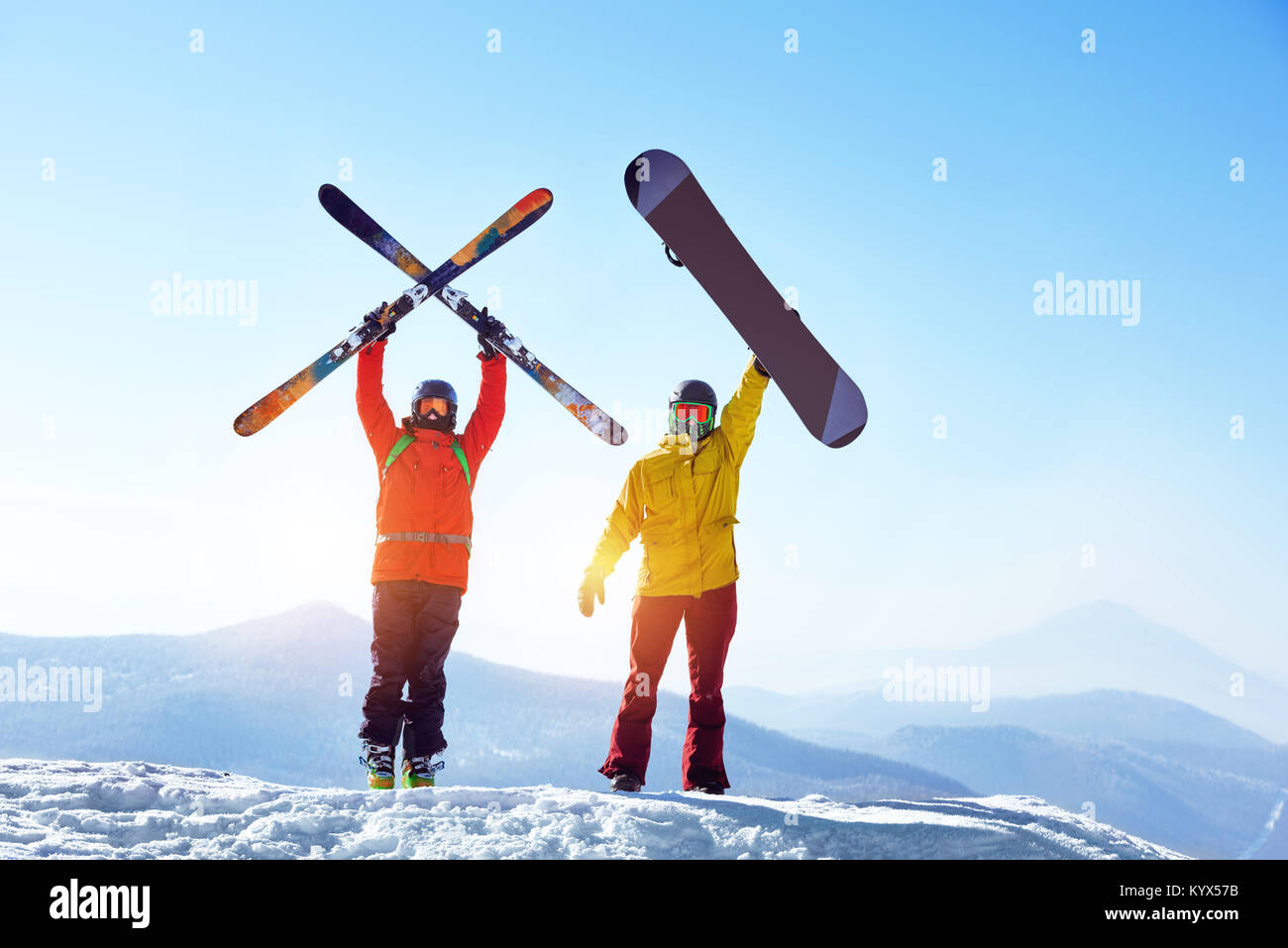 Aktive Skifahrer und Snowboarder gegen Berge Stockfoto