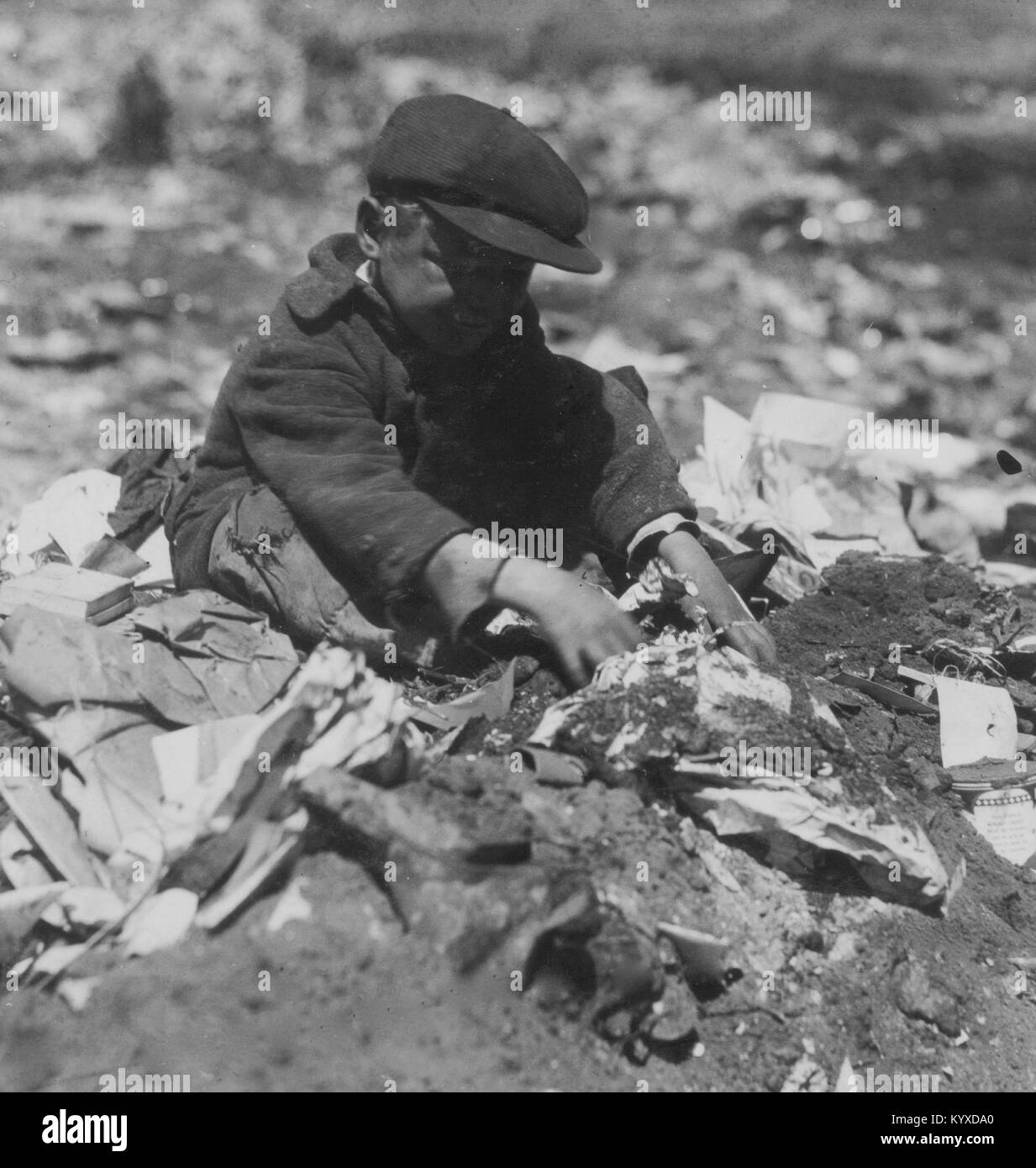 Auf angenehmer Straße Dump geht eine junge Schnitzeljagd durch den Papierkorb. Stockfoto