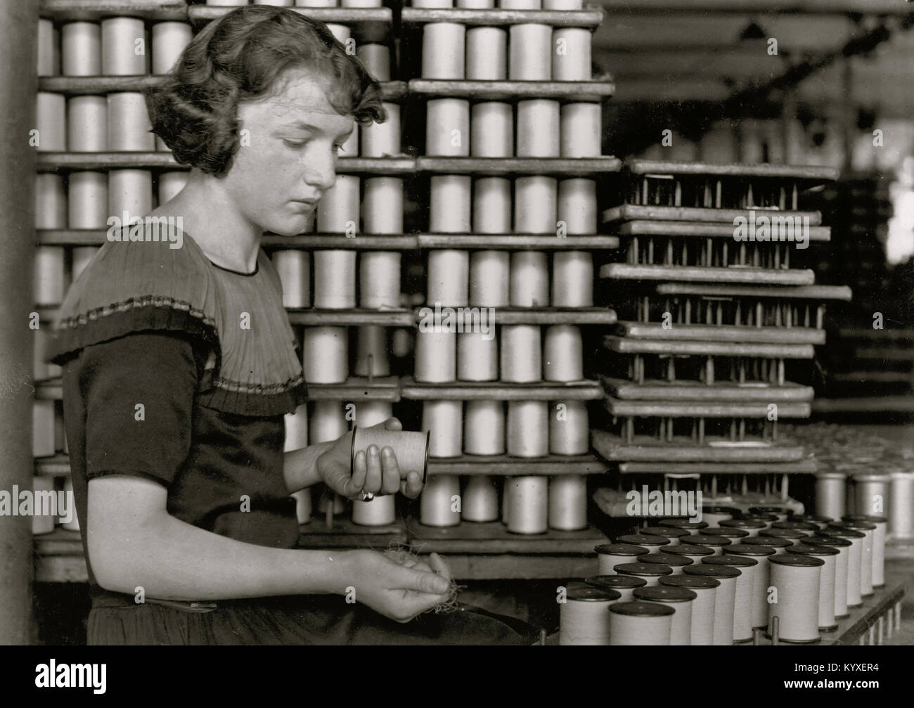 Young Girl Stapel Spulen der Seidenfaden Stockfoto