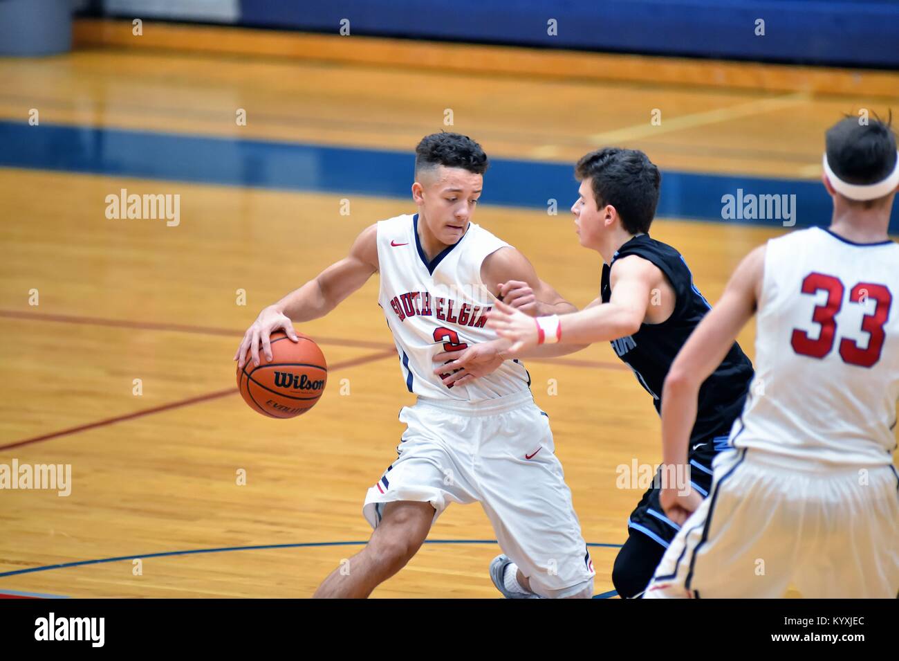 Point Guard Anfang einer Bewegung in der Vergangenheit ein Verteidiger nach dem Passieren des Centre Court fahren. USA. Stockfoto