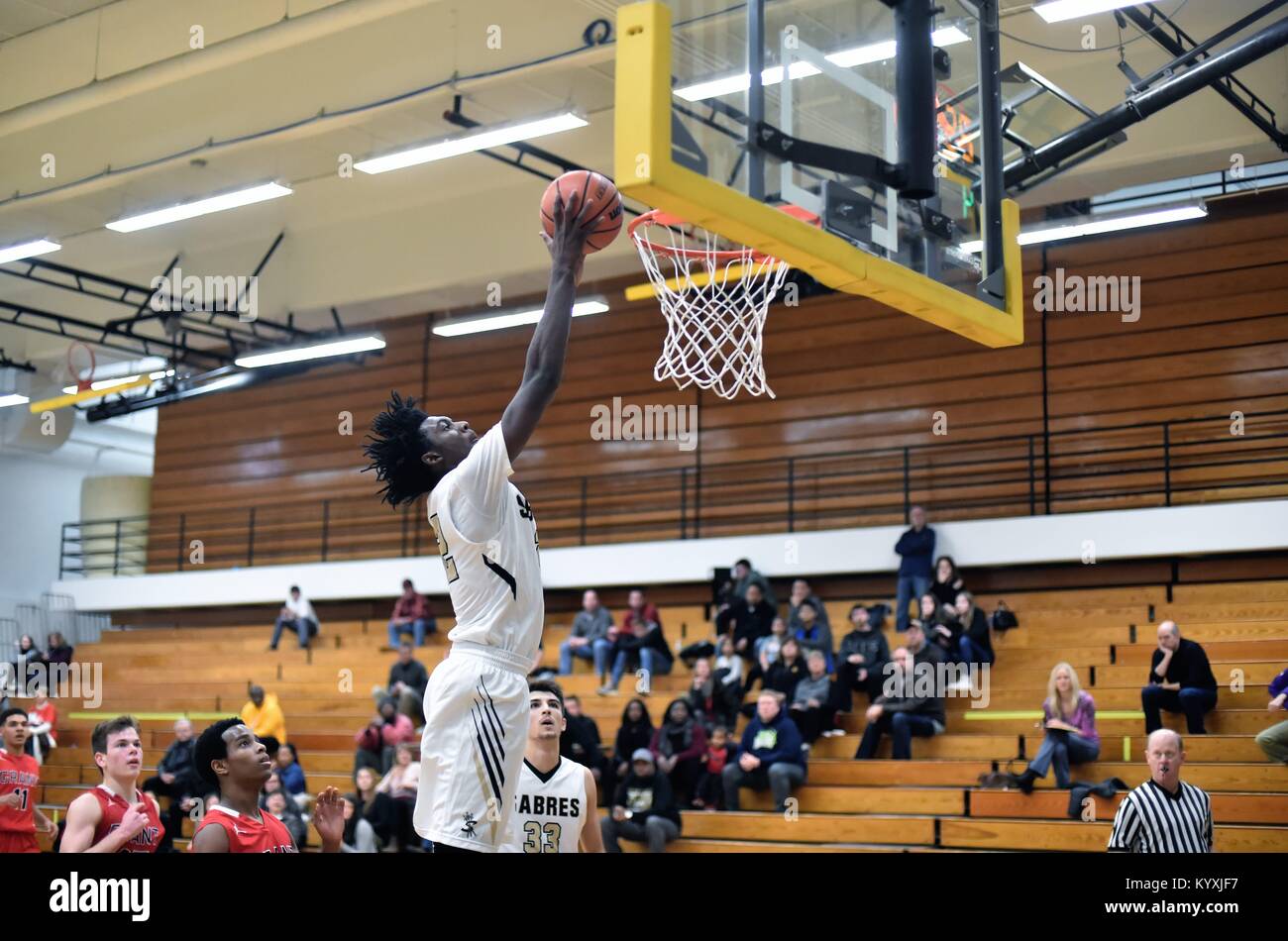 Allein aus dem Boden, ein High School vorwärts slams Home zwei Punkte während eines High School Basketball Spiel. USA. Stockfoto