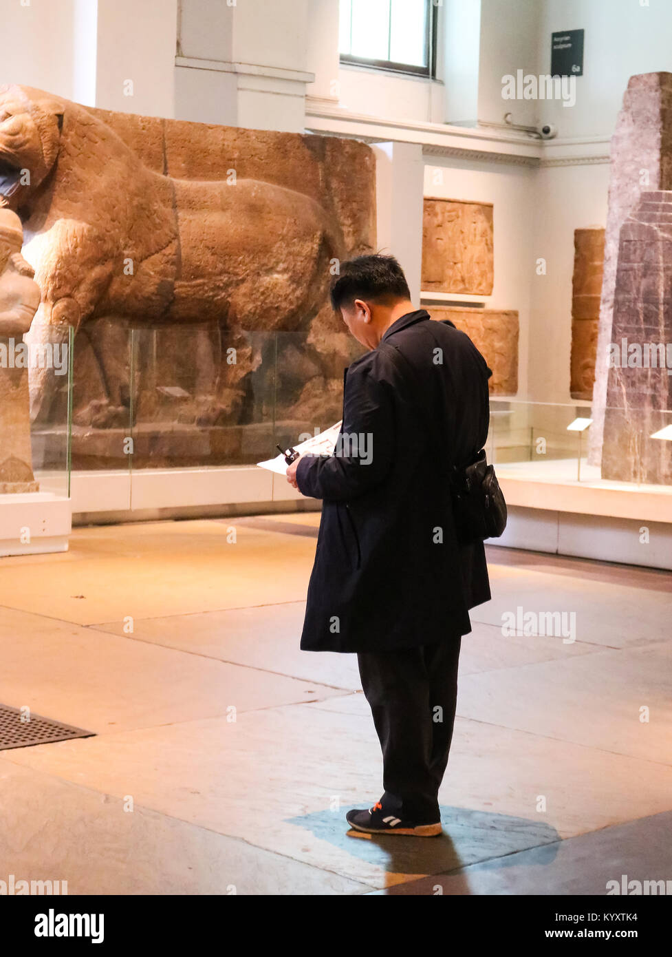 Chinesischer Mann Tourist in British Museum mit Audio Guide und Karte für Self-guided Tour - London England 1 - 10 - 2018 Stockfoto