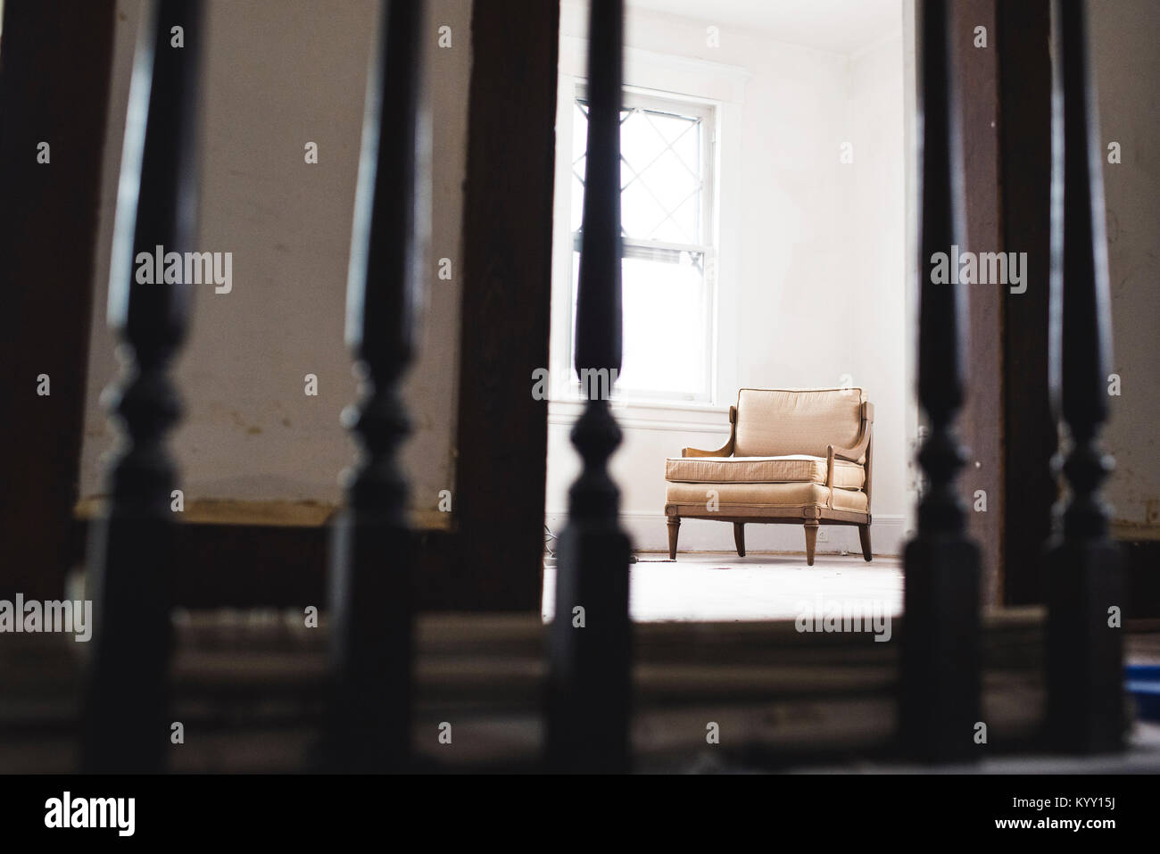 Stuhl im heimischen Zimmer durch metallische Geländer gesehen Stockfoto