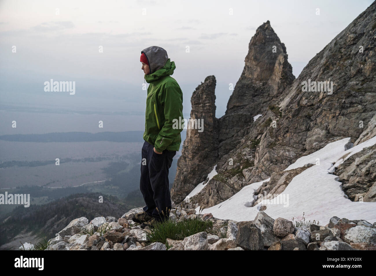 Seitenansicht des Menschen mit den Händen in den Taschen auf die Berge im Winter Stockfoto