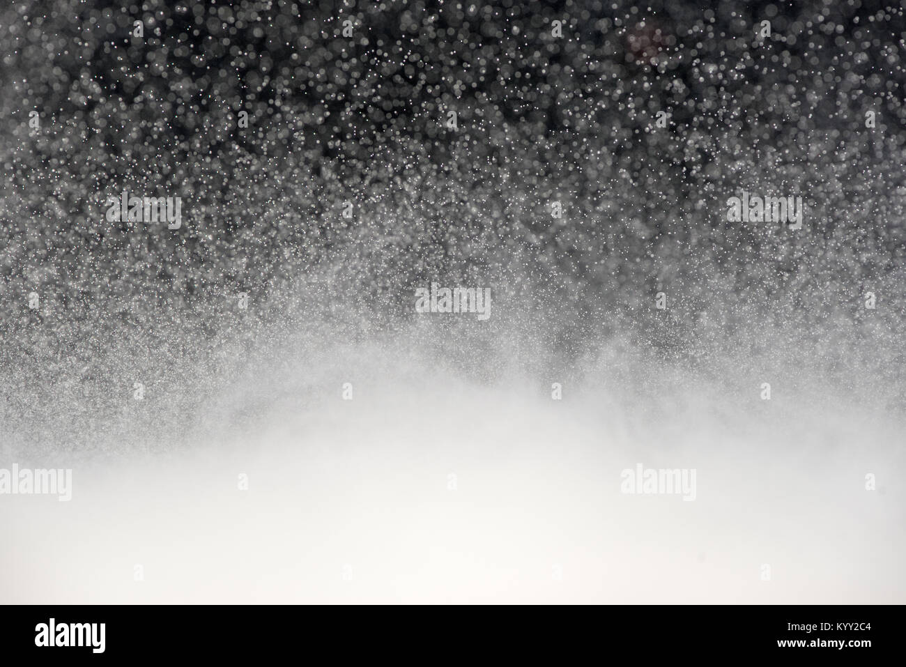 Weißer Schnee wie Partikel, ähnlich einem Schneesturm erstellt ein Bokeh verschwommenen Hintergrund wie die Tausende von Partikeln in Flüssigkeiten gegen a b ausgesetzt hängen Stockfoto