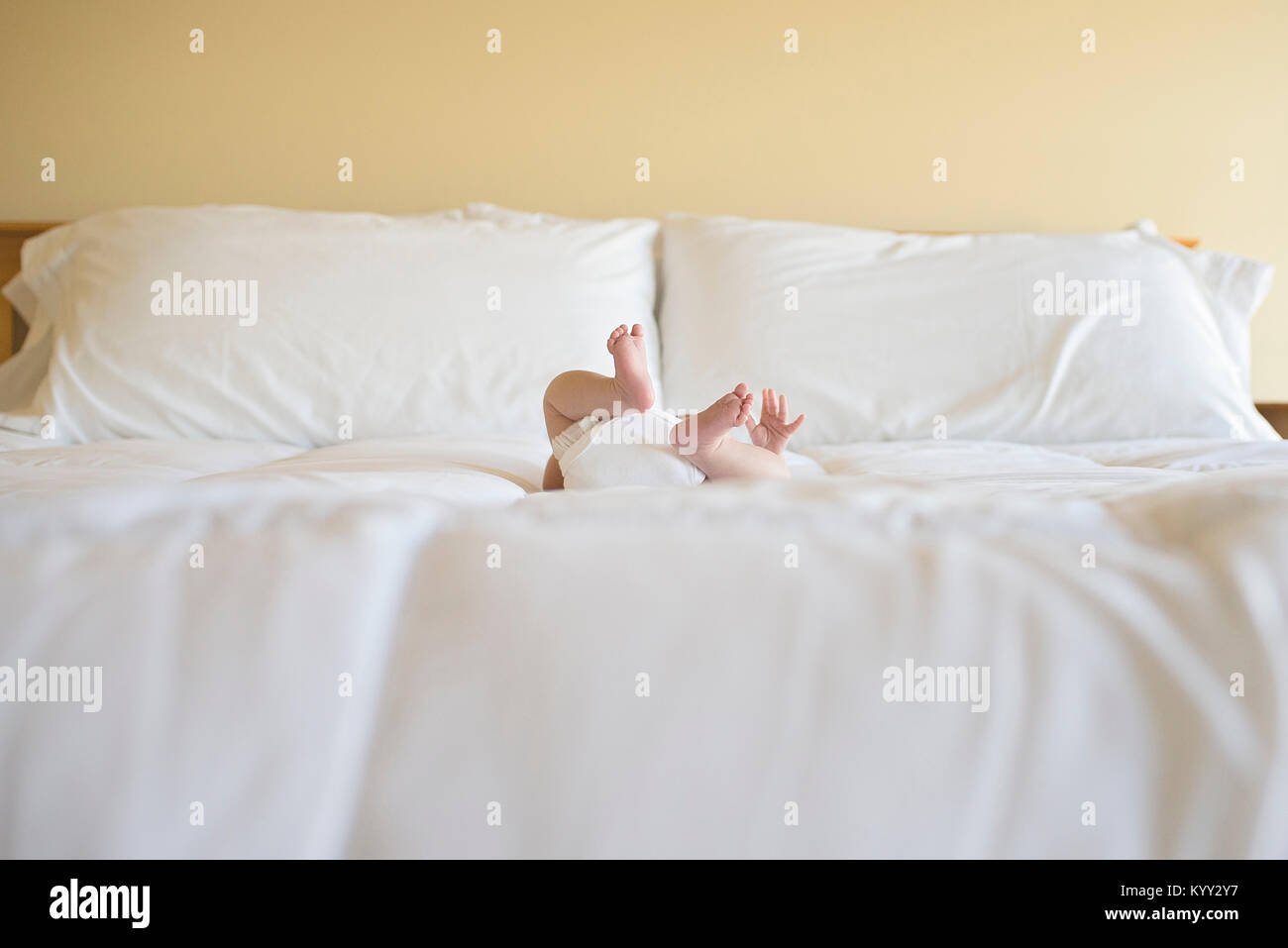 Geringen Teil des Babyjungen am Bett zu Hause liegen Stockfoto