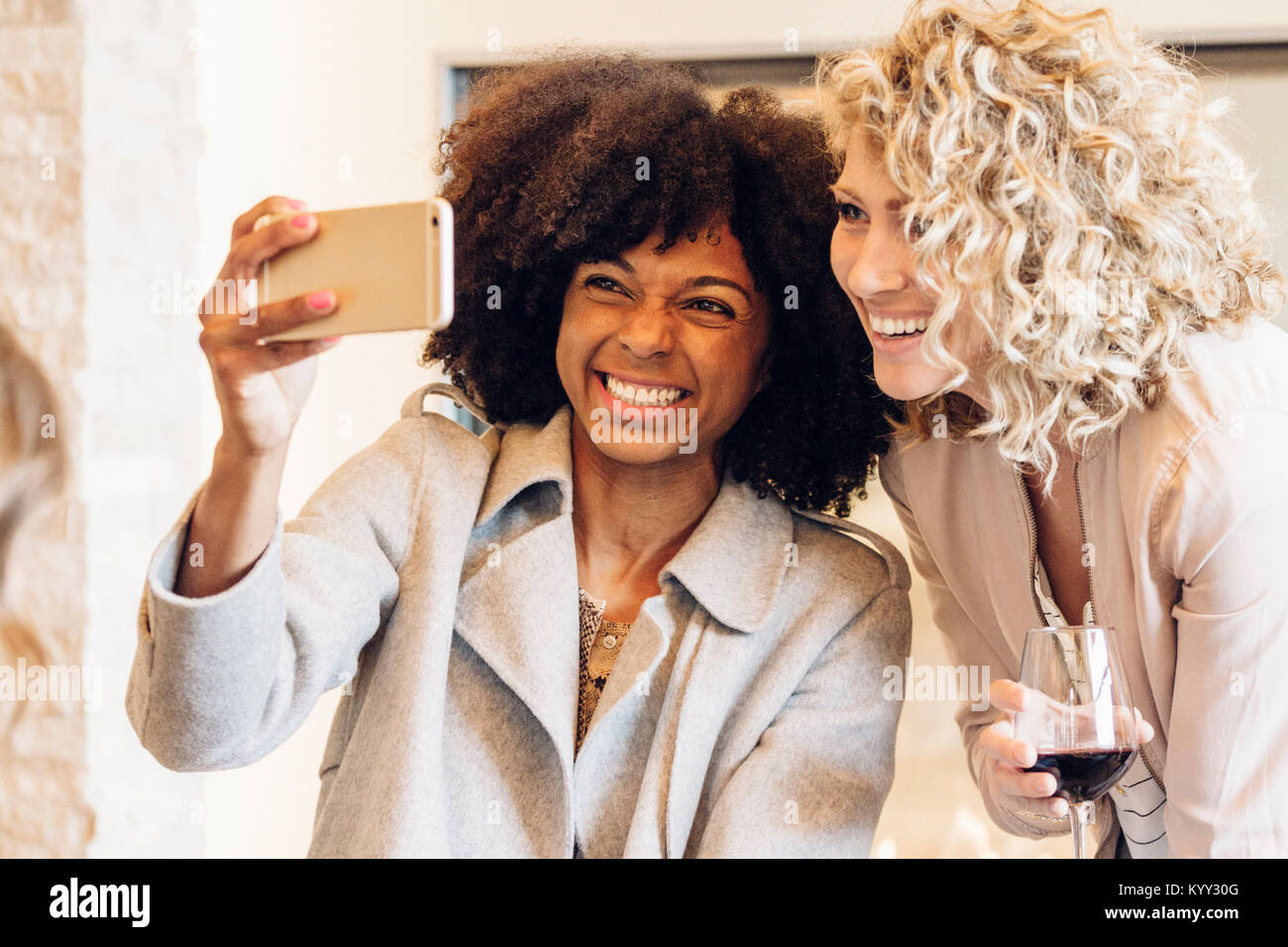 Fröhliche Geschäftsfrauen, die selfie mit Smart Phone im Hotel Stockfoto