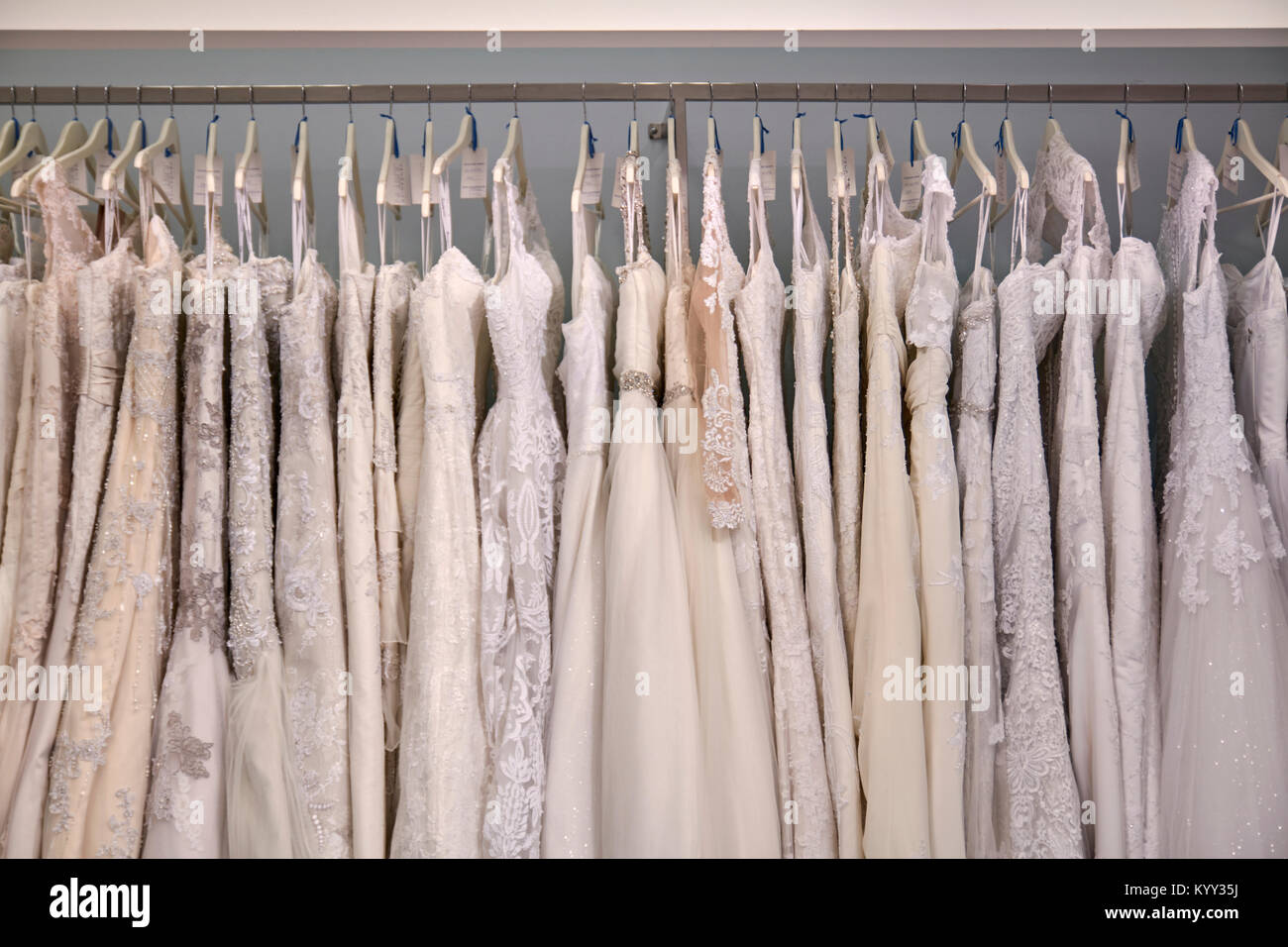 Hochzeitskleider hängen am Kleiderständer im Laden Stockfoto