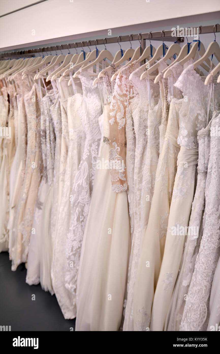 Hochzeitskleider hängen am Kleiderständer im Brautladen Stockfoto