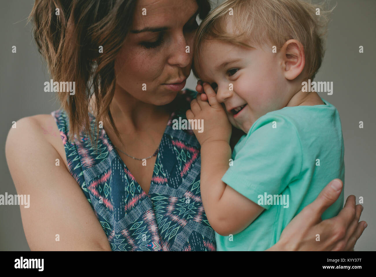 Mutter trösten Sohn, während ihn zu Hause tragen Stockfoto