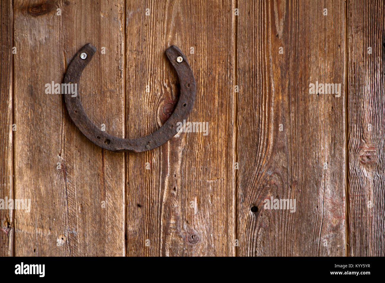 Alte Pferde Schuh zu einer Verwitterten hölzernen Tür genagelt Stockfoto