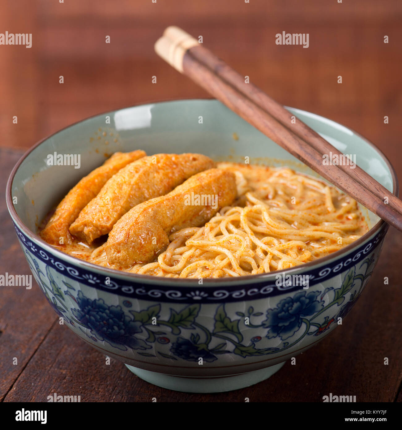 Heiß und würzig Nudelsuppe curry mit Stäbchen auf dem Tisch, populäre Nahrungsmittel in Asien. Stockfoto