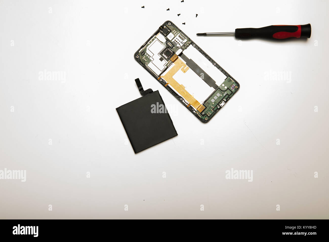 Studio shot high-angle View close-up von Präzisions Schraubendreher und zerlegt Mobiltelefon mit Akku in ein Konzept der Austausch, Reparatur ein Stockfoto