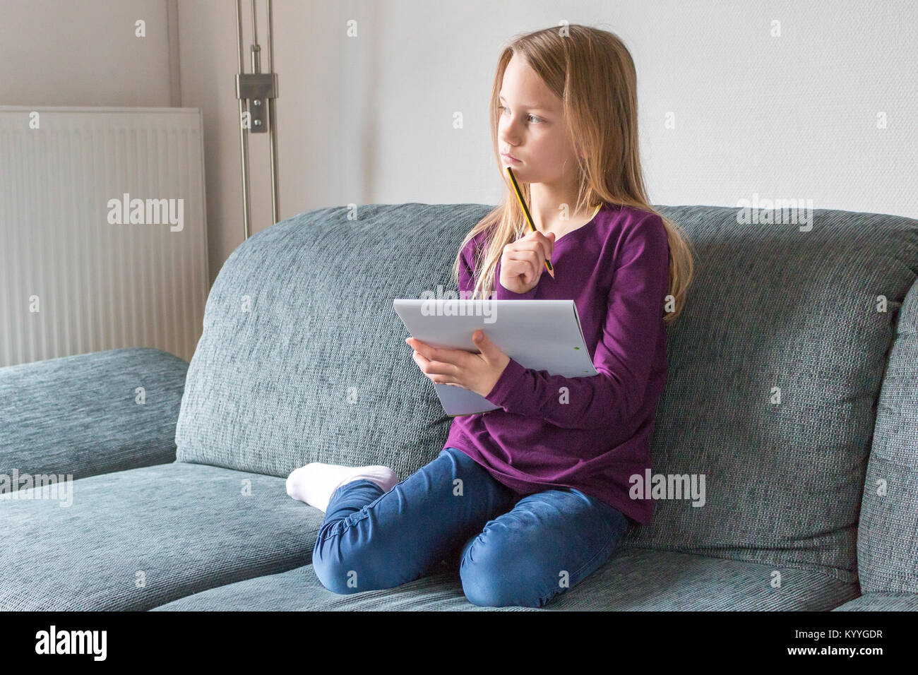 Mädchen sitzt auf dem sofa -Fotos und -Bildmaterial in hoher Auflösung –  Alamy