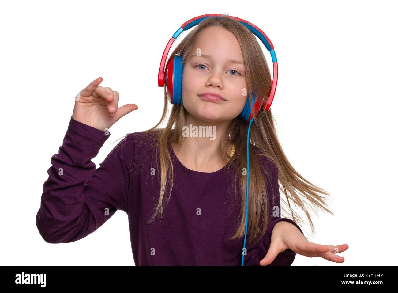 Ein 9 Jahre altes Mädchen hört Musik über Kopfhörer und Tänze Stockfoto