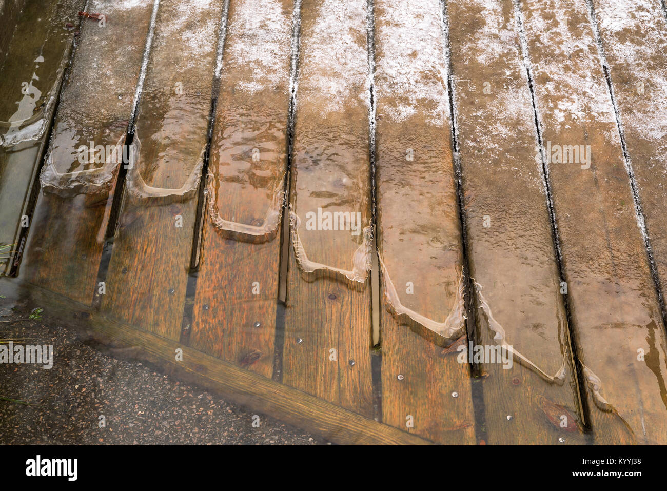 Eis und Wasser Holzbohlen auf Spaziergang Brücke. Stockfoto