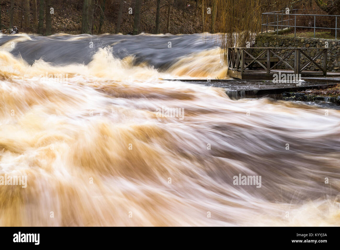 Rapids oder Wildwasser raging Vergangenheit eine leere Holz- Aussichtspunkt mit Sitzbank und Geländer. Der Fluss Morrumsan in Südschweden. Stockfoto