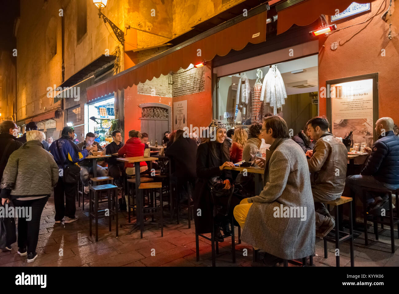 Die Menschen sitzen in Restaurants, Cafés und Bars in der Via Pescherie Vecchie, eine Straße in der Stadt Bologna, Italien bei Nacht Stockfoto