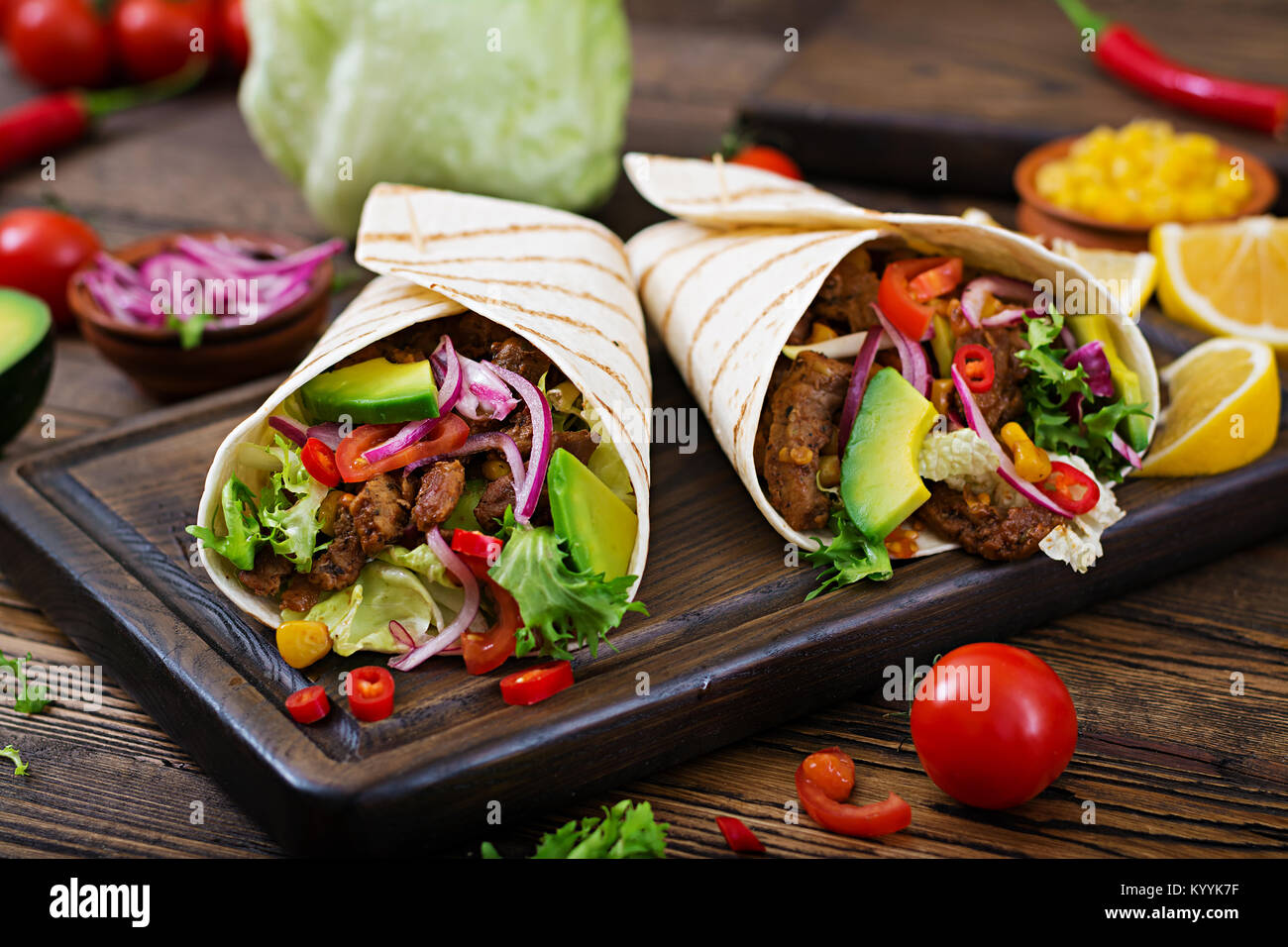 Mexikanische Tacos mit Rindfleisch in Tomatensoße und Avocado Salsa Stockfoto