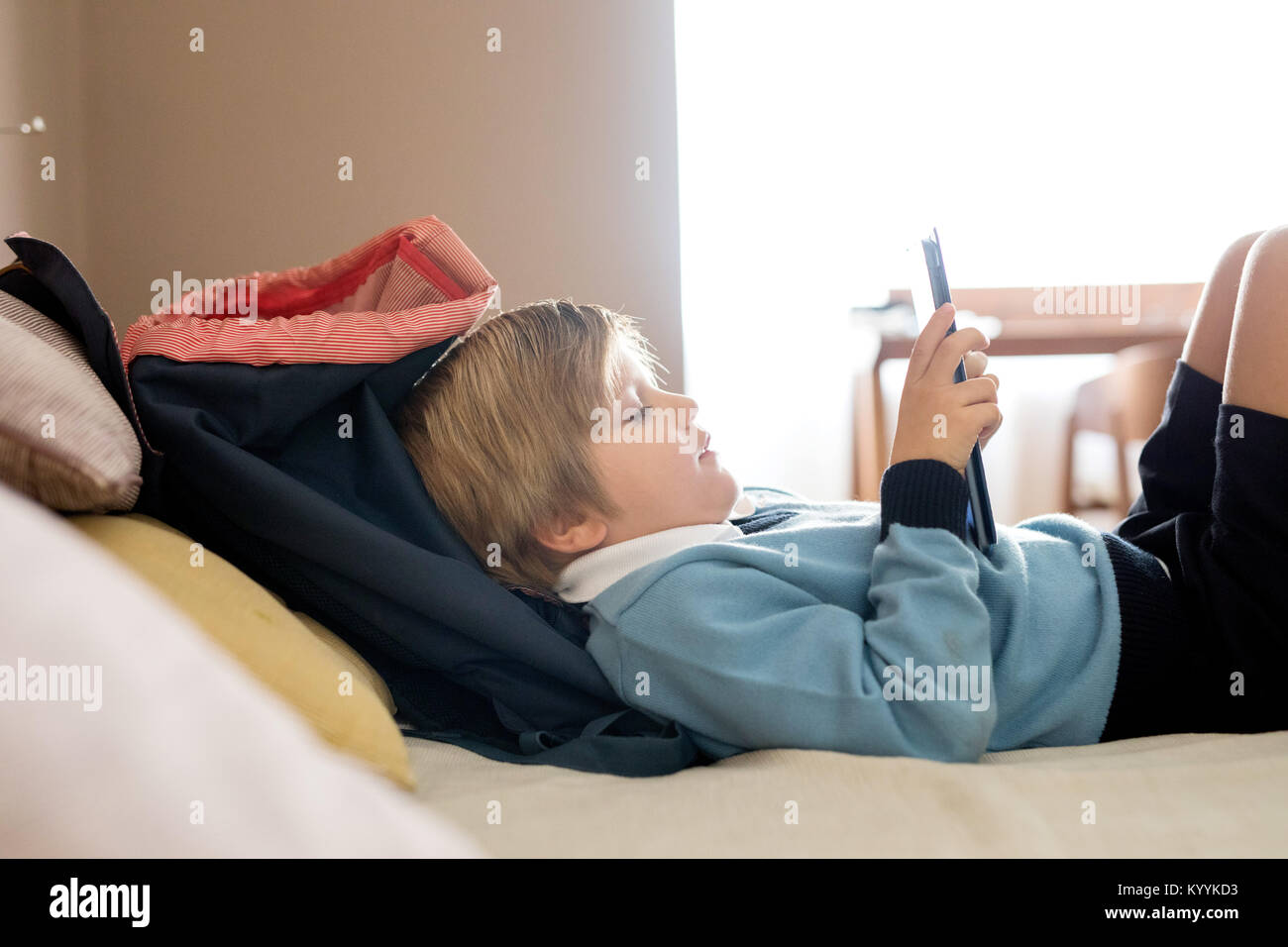 Junge mit digitalen Tablet im Schlafzimmer im Schlafzimmer Stockfoto