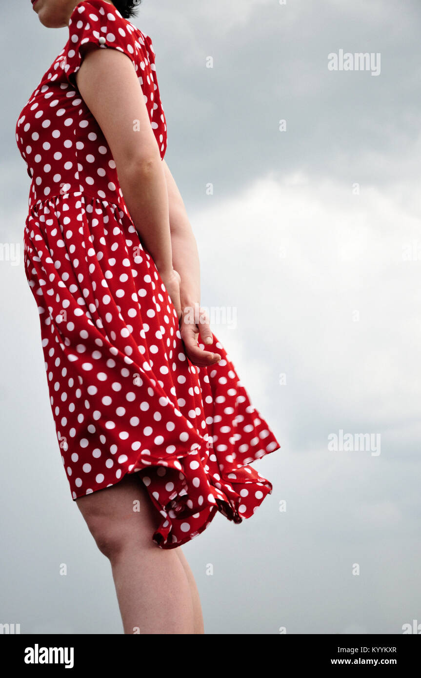 Frau in rot gepunkteten Kleid stehen im Freien Stockfoto