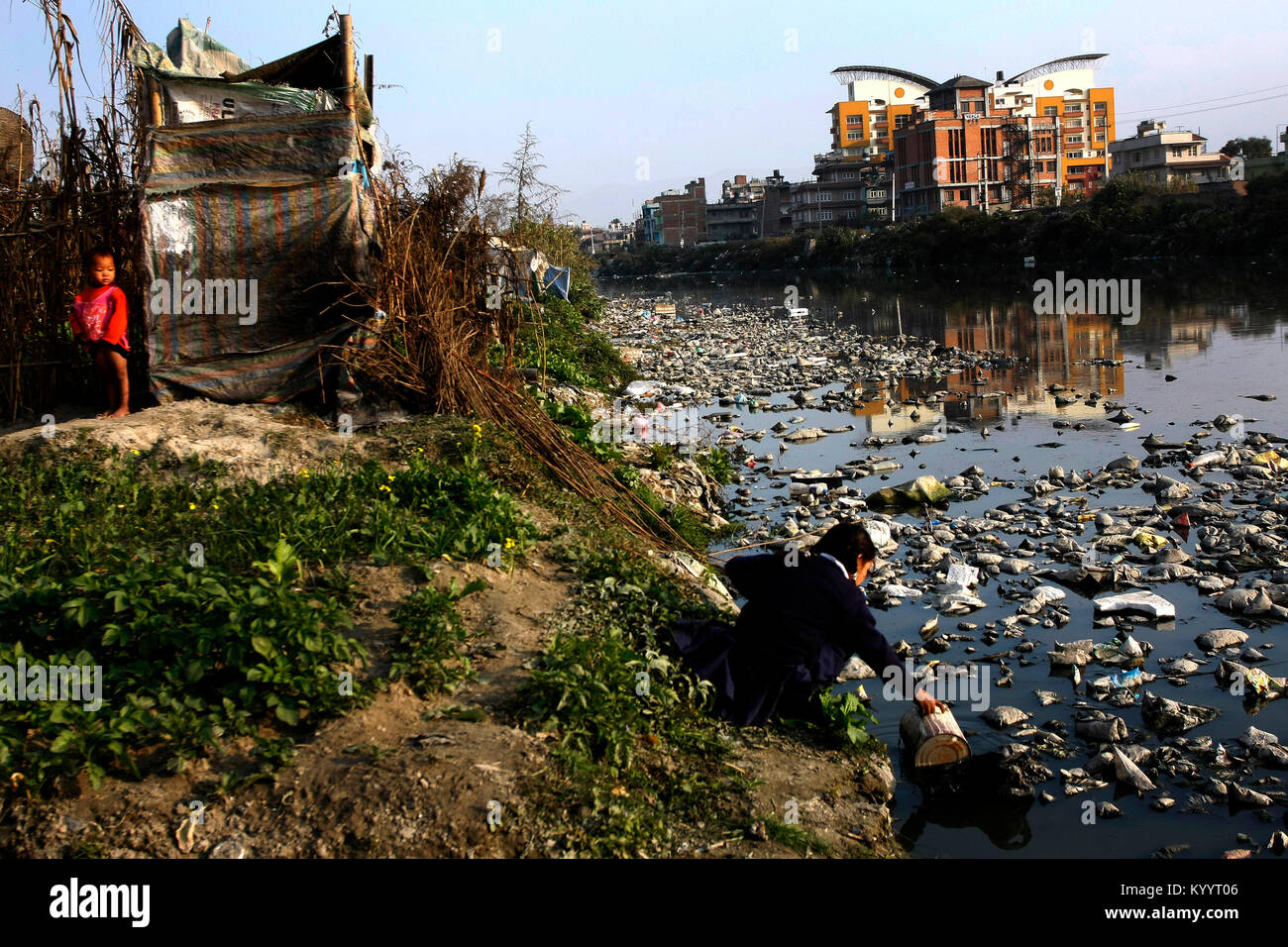Laxmi Lama auf sammelt Wasser aus verschmutzten Bagmati River, um sie zu waschen Geschwister an hausbesetzer Siedlung in Thapathali. Lama kehrt zurück Ihr Haus während h Stockfoto