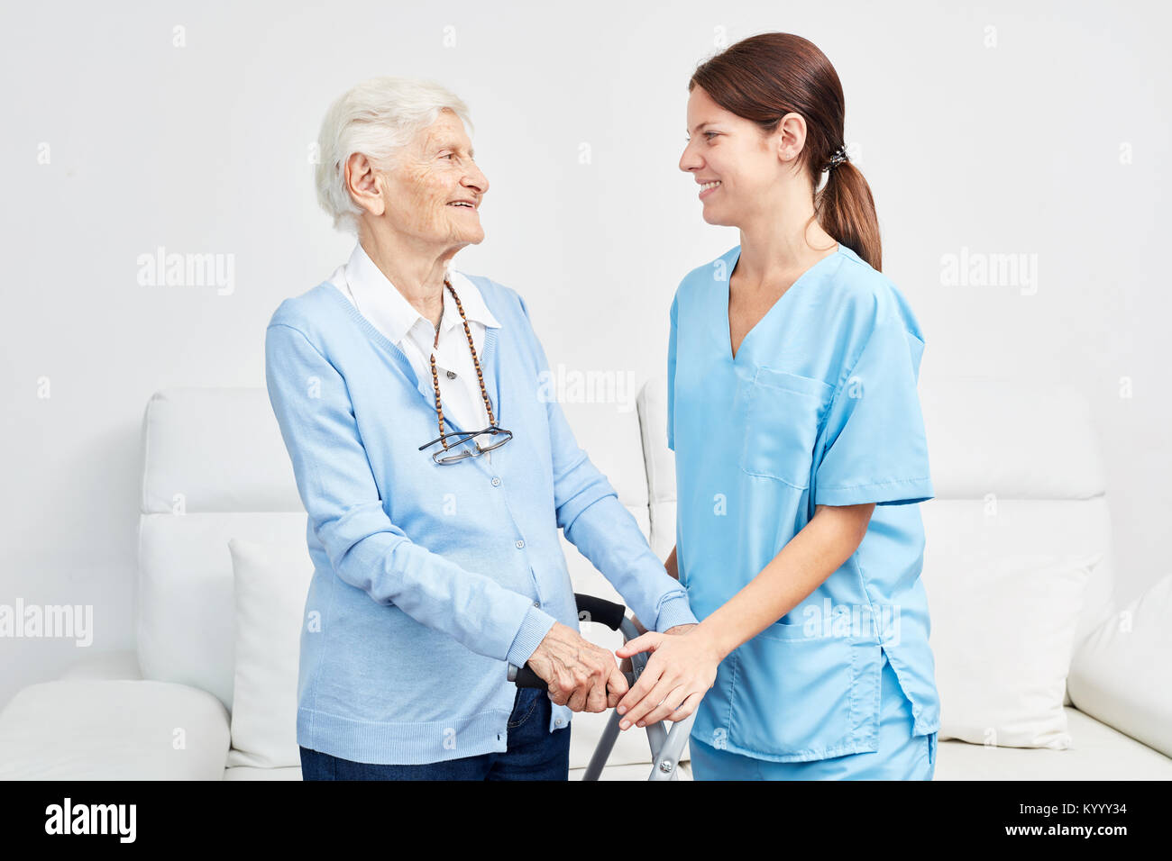 Betreuer oder Pfleger unterstützt ältere Frau mit Walker im rehab Stockfoto