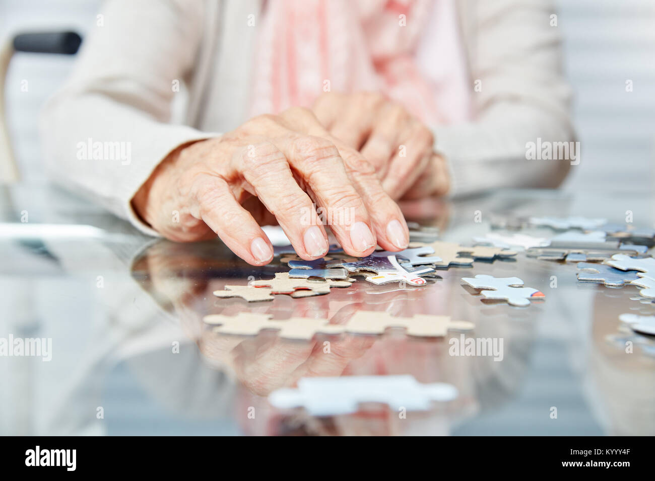 Die Hände der Senioren spielen Puzzle als Demenz Prävention in den Ruhestand home Stockfoto