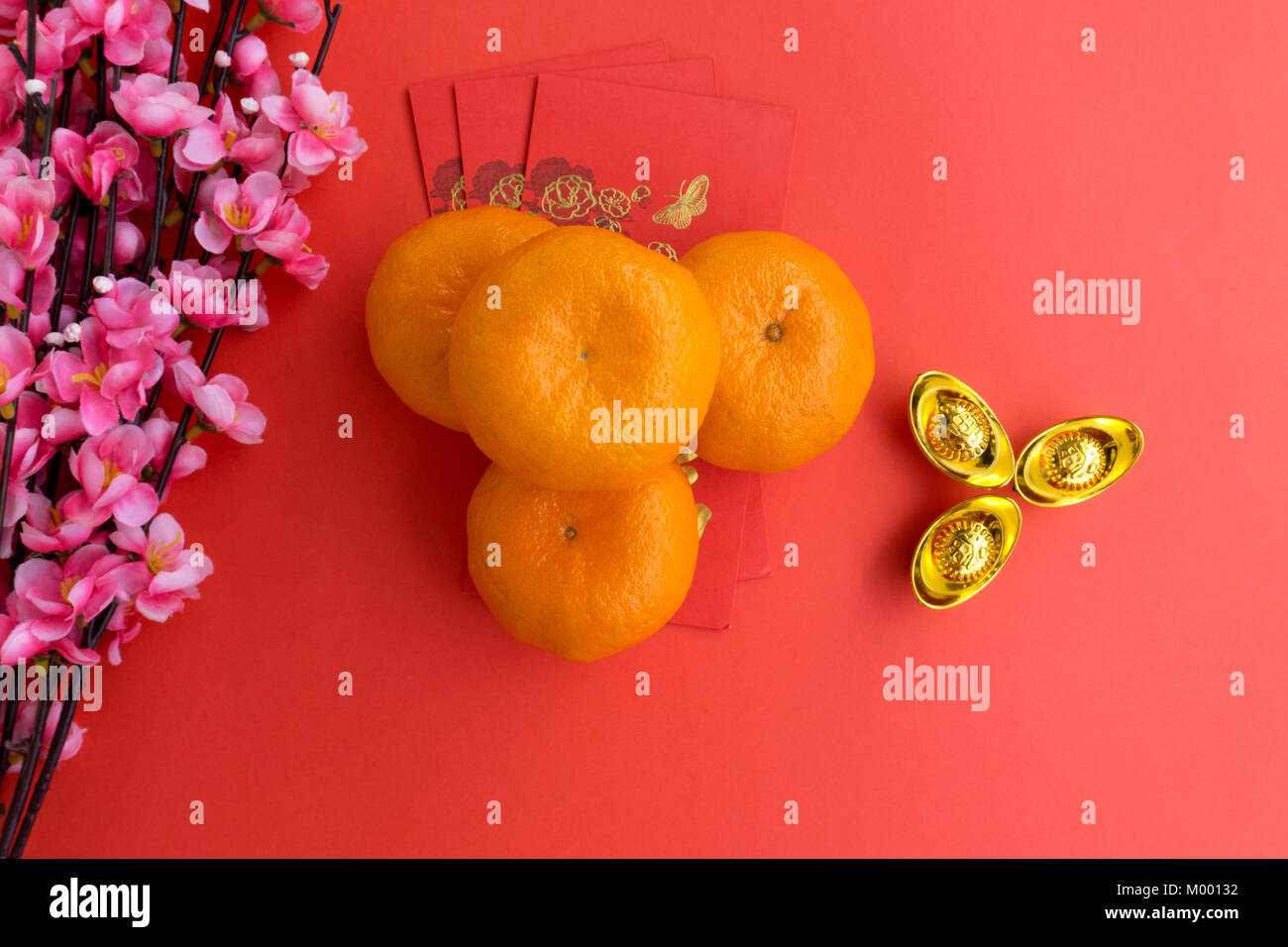 Das chinesische Neujahr Hintergrund Konzept - Chinesisches Neujahr Hintergrund Ornamente, Mandarin Orange, rote Umschläge, Pflaume Blumen und Gold Ingots Stockfoto