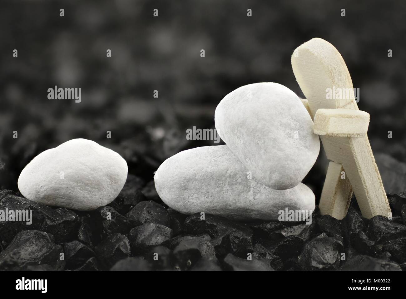Holz- mann Stapel weiße Kieselsteine Stockfoto