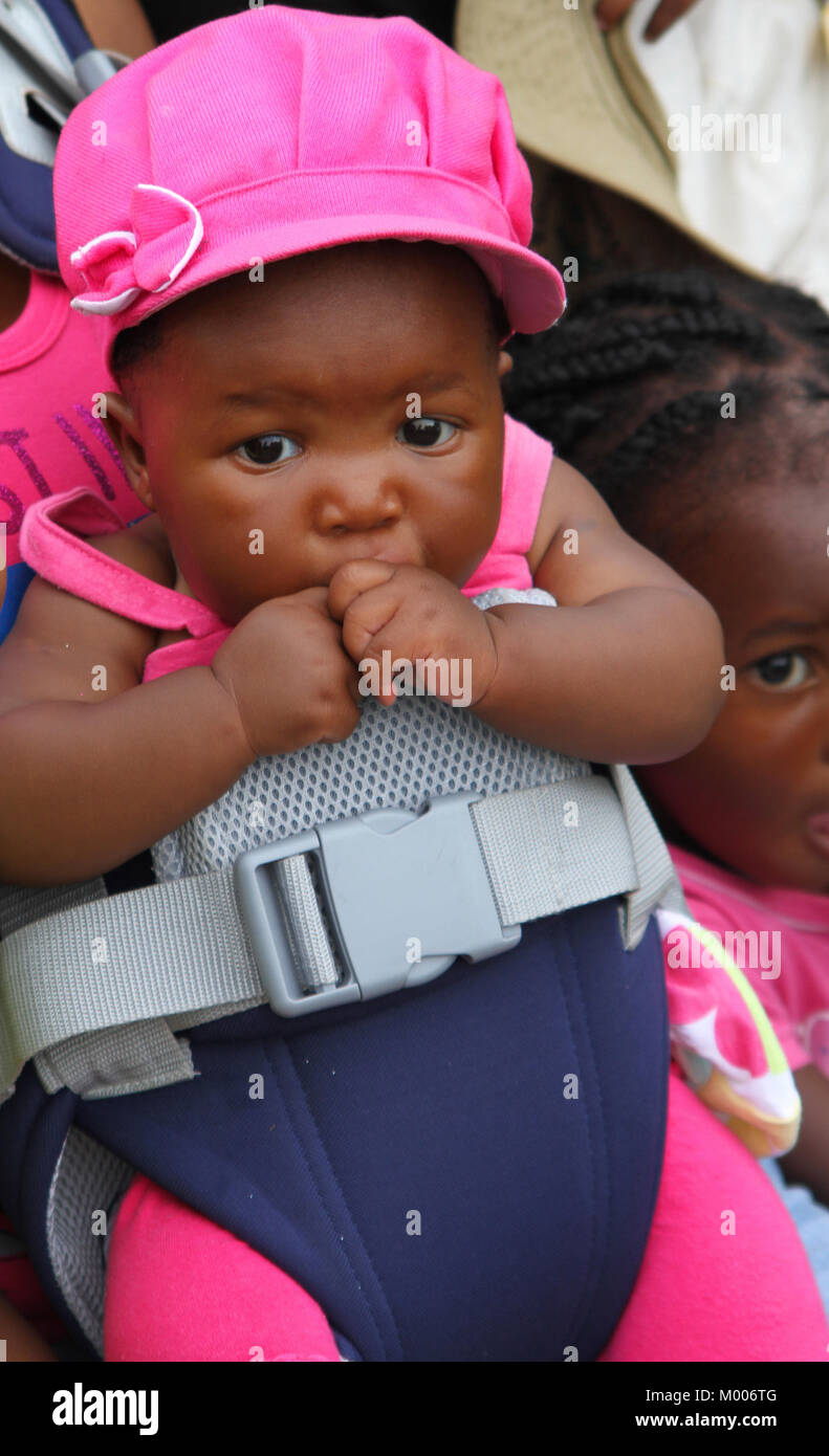 Afrikanische Baby auf Mutters Brust, Mosi-Oa-Tunya, Viktoriafälle, Simbabwe geschnallt. Stockfoto