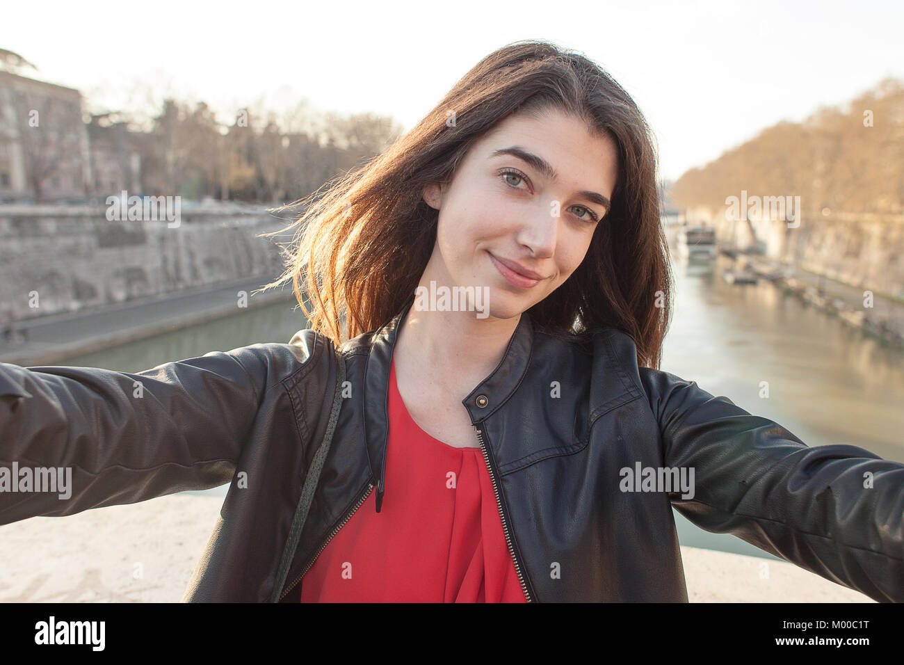 Schöne und elegante junge Mädchen eine selfie mit einem Fluss hinter sich. Europa reisen. Stockfoto