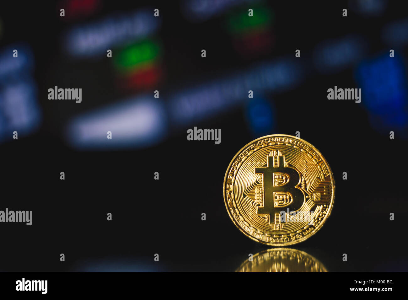 Golden Bitcoin Münze auf dunklem Hintergrund mit Reflektion Stockfoto