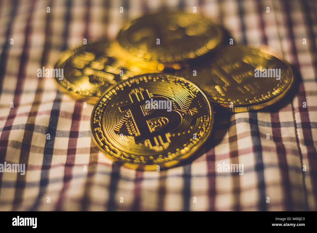 Stapel der goldenen Bitcoiin Münzen auf gestreiften Hintergrund Stockfoto