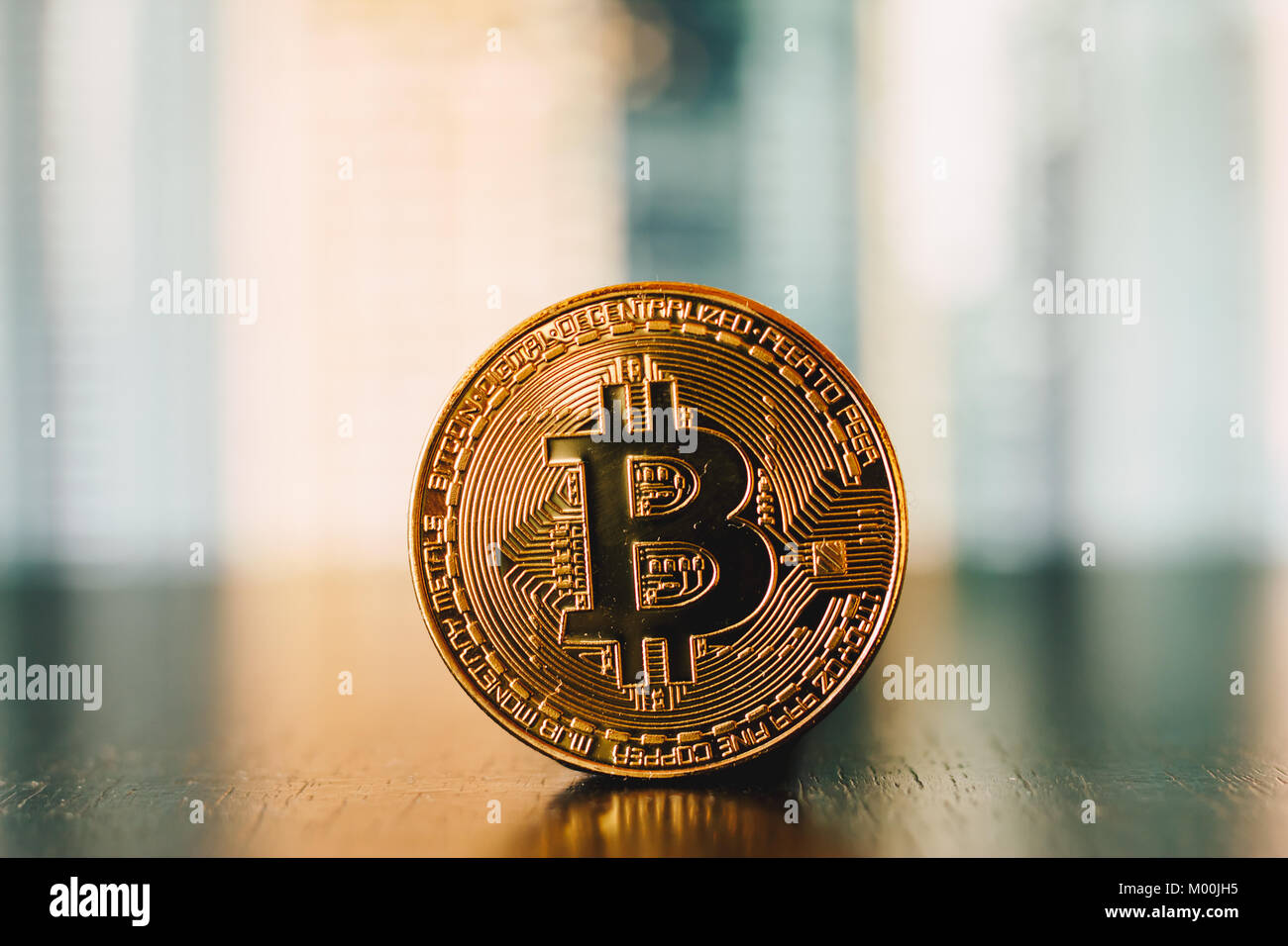 Golden bitcoin Münze auf eine Reflexion der Oberfläche mit grün und gelb gestreiften Hintergrund Stockfoto