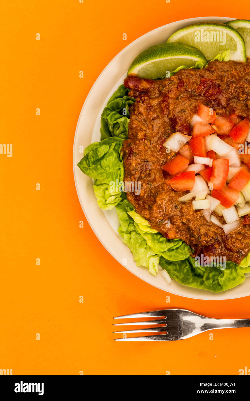 Würzige Mexikanische Rindfleisch Taco Fleisch und Salat mit frischen Limetten gegen einen orangen Hintergrund Stockfoto