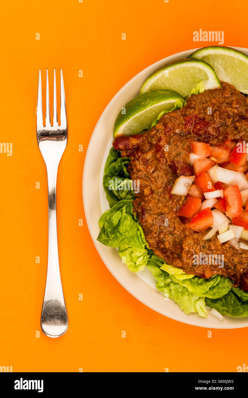 Würzige Mexikanische Rindfleisch Taco Fleisch und Salat mit frischen Limetten gegen einen orangen Hintergrund Stockfoto