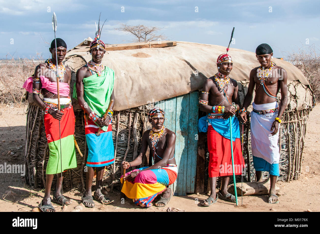 Fünf nach Samburu Masai Männer vor einer traditionellen manyatta Hütte in einem Dorf in Samburu, Kenia, Ostafrika posing Stockfoto