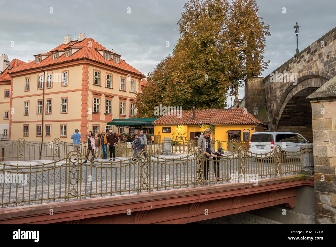 Eine Frau und ein kleiner Junge blicken über eine Brücke, die die Čertovka überquert, einen Wasserkanal im Prager Kleinseite in der Nähe des Cafés Marnice Stockfoto