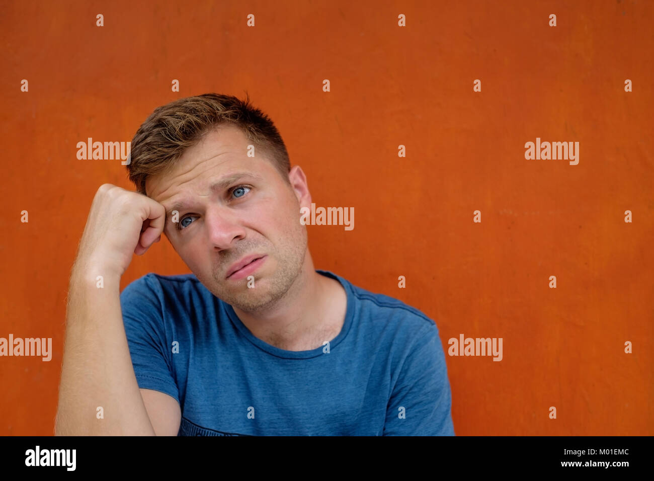 Close up Portrait der kaukasischen enttäuscht betont jungen Mann auf roten Hintergrund. Er ist, zu weinen. Stockfoto