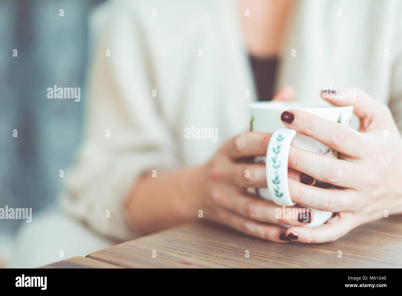 Junge Frau mit roten Nagellack teilen Geheimnisse am Küchentisch. Stockfoto