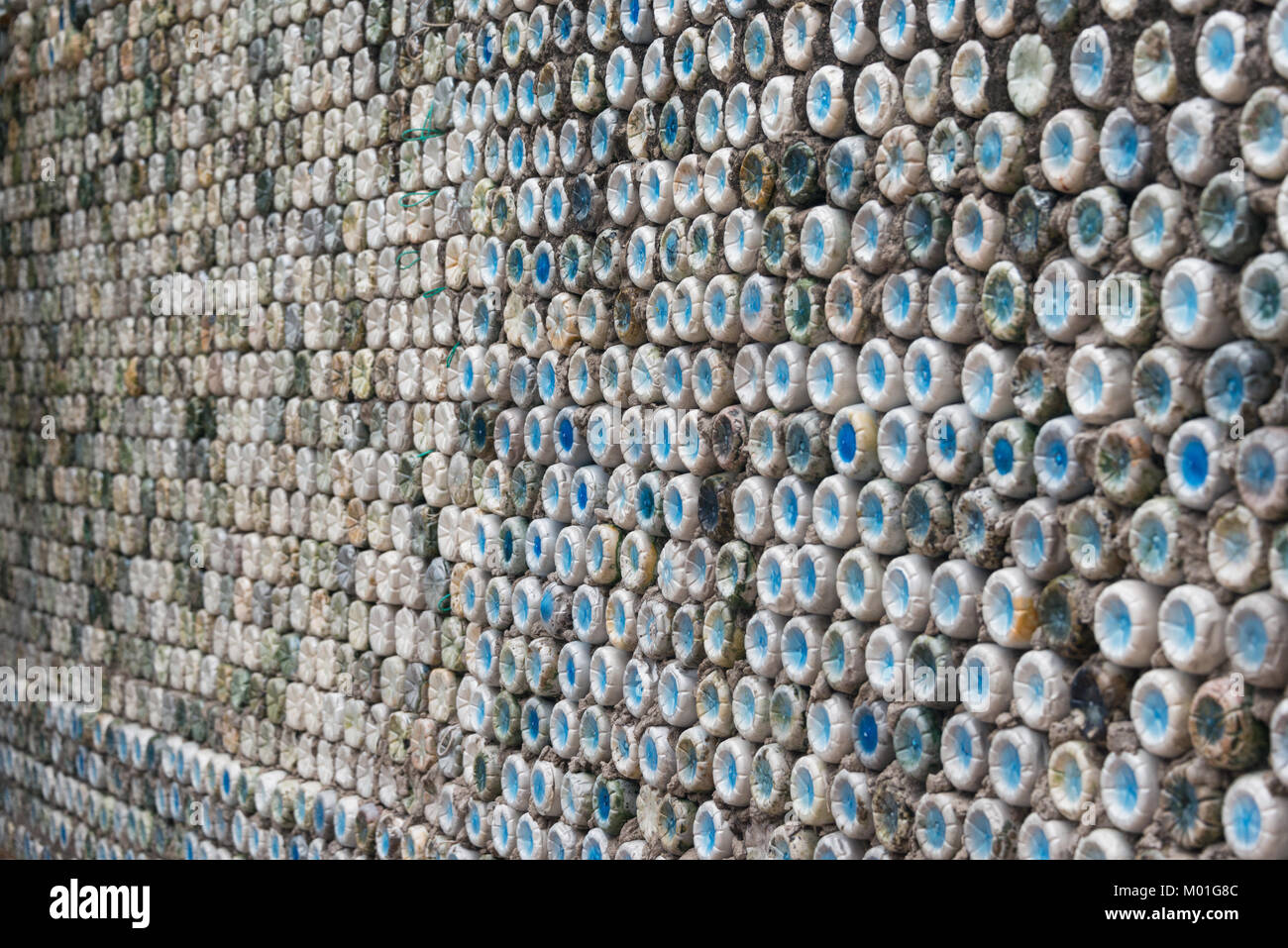 Flasche recycling: Plastikflaschen, die in Beton gesetzt wurden, eine Flasche an der Wand zu bilden Stockfoto